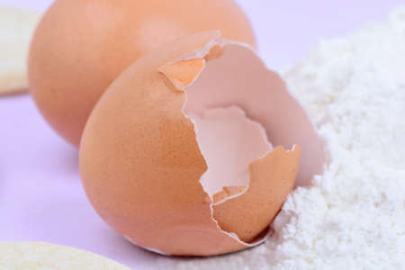 Eggs and pile of flour on pink background close-upの写真素材