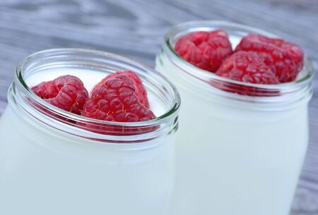 Raspberry with yogurt in a jars on table closeupの写真素材