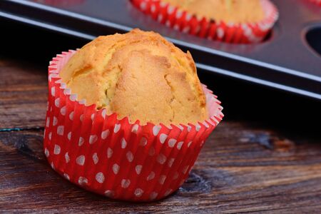 Muffins and tray on wooden table