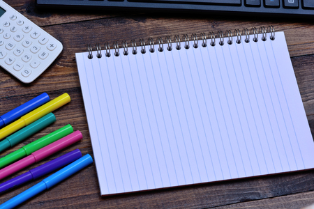 Notepad with calculator and keyboard computer on wooden tableの写真素材