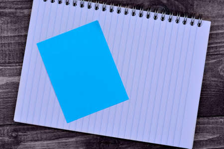 Notepad with empty notes on wooden tableの写真素材