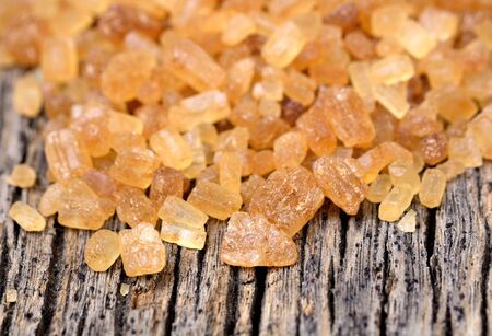 Many sugar brown candy crystals on wooden tableの写真素材
