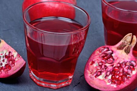 Pomegranate juice in a glasses on slate close-upの写真素材