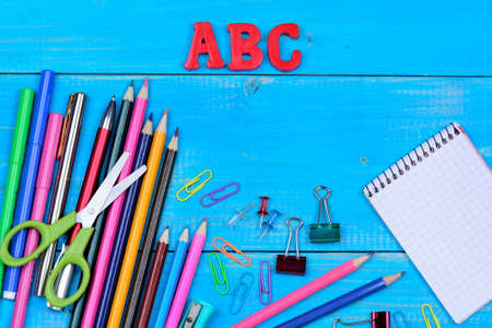 Many objects school on blue wooden table close-up