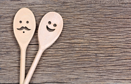 Kitchen wooden spoons with man and smiley face on table close-upの写真素材