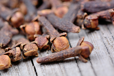 Heap of cloves on rustic wooden table close-upの写真素材