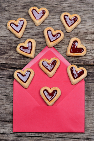 Many heart cookies in an envelope on wooden tableの写真素材