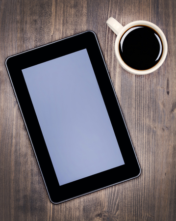 Digital tablet pc and coffee cup on deskの写真素材