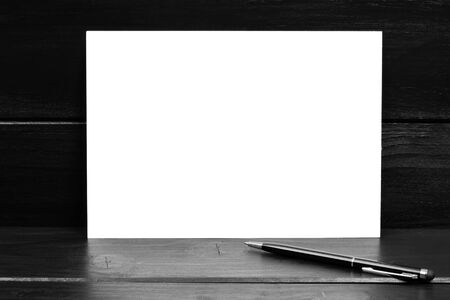 Empty paper with pen on black wooden table