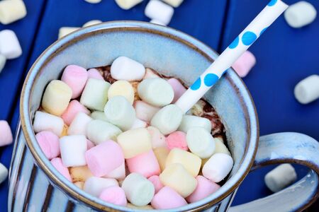 Hot chocolate with mini colorful marshmallow in a cup on a wood tableの写真素材