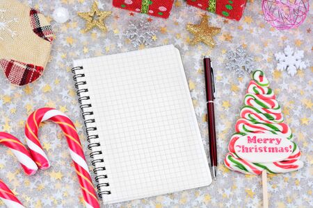 Empty notebook with christmas ornament on shiny tableの写真素材