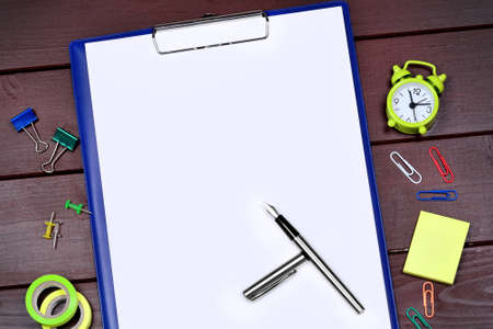 Clipboard with business objects on a wood tableの写真素材
