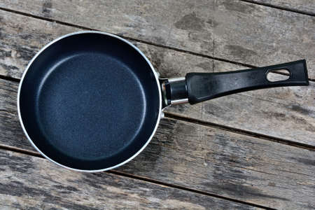Empty iron pan on a wood tableの写真素材
