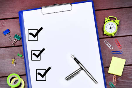Close up of clipboard with business objects on a wooden tableの写真素材