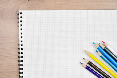 Close-up of empty notebook with many school objects on desk