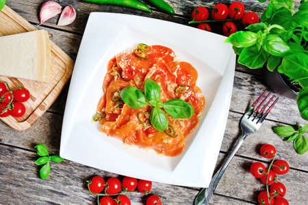 Red heart ravioli with cherry tomato, mozzarella, parmesan and basil close upの写真素材