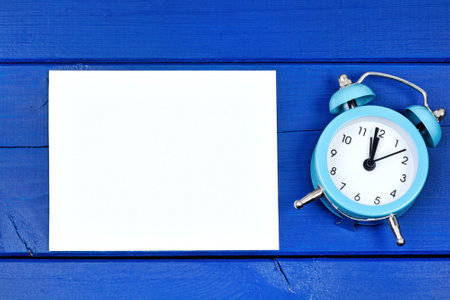 Empty paper with alarm clock. Top view
