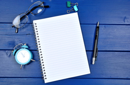 Empty notepad page on a blue wooden deskの写真素材