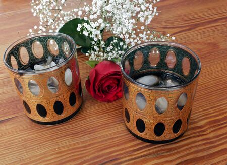 Flowers and Cocktails. Old-fashion, 1974 glasses with ice and whiskey on a wood table. Gold Trimmed.の写真素材