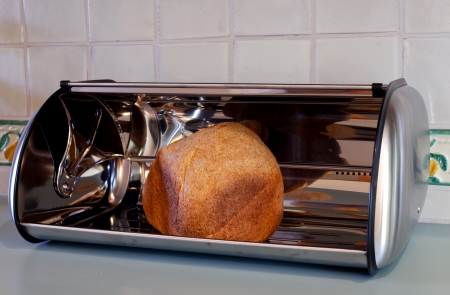 Homemade whole wheat bread in a stainless steel open bread box の写真素材