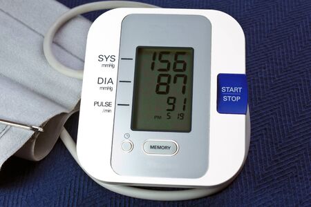 Bood Pressure Monitor with cuff and showing hypertension.