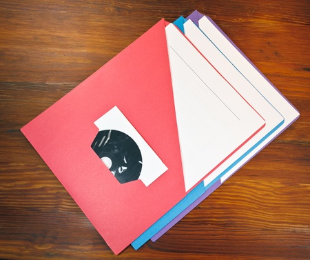Presentation folders with Disc on a wooden table.
