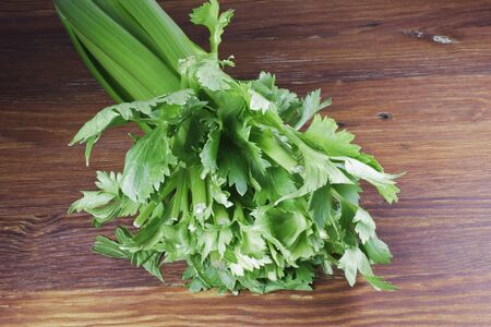 Side view of Celery greens on a wooden cutting boardの写真素材