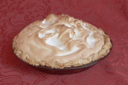 Sideview of meringue pie on a red table clothの写真素材