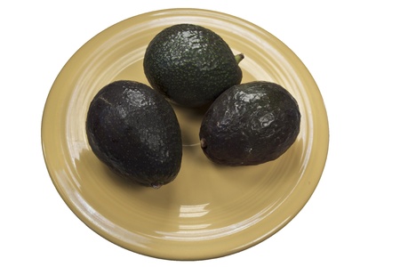 Avocados on Yellow Plate and isolated on a white backgroundの写真素材