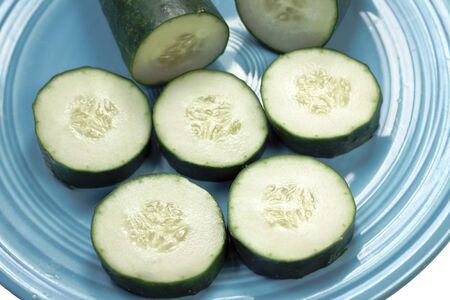 Cucumber slices isolated on a turquoise plate の写真素材