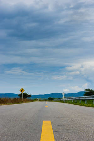 long road and Curved signs under blue skyの写真素材