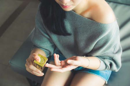 Woman is applying the cream on her fingertipの写真素材
