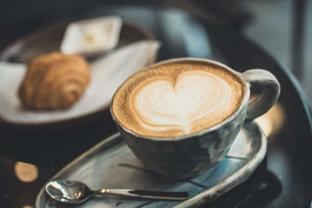 Hot Cappuccino and Croissant on a tableの写真素材
