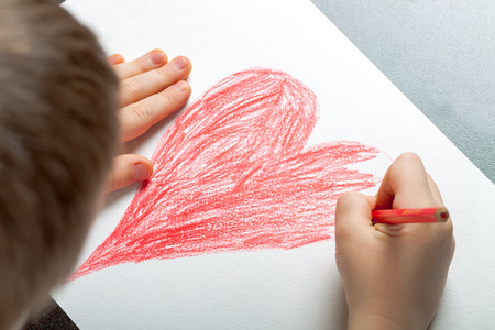 little boy draws with colored pencils drawingの写真素材
