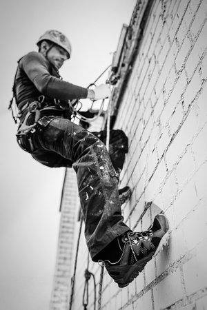 Male worker rope access industrial working at height tank oil wearing harness, helmet safety equipment rope.の写真素材