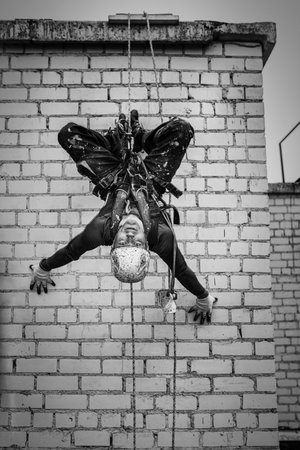 Male worker rope access industrial working at height tank oil wearing harness, helmet safety equipment rope.の写真素材