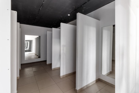 Empty retail space with a black ceiling and a dirty floor, immediately after repair