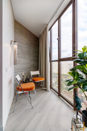 Small clean cozy balcony with windows in tiny city apartment with plants.の写真素材