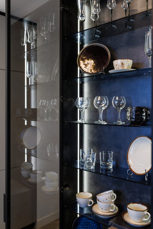 Modern glass kitchen cabinet for crystal glasses with yellow warm backlight.の写真素材