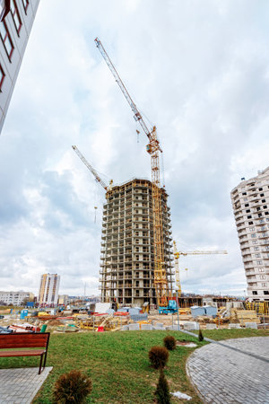 Crane and building under construction against blue sky.の写真素材