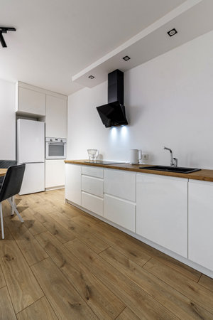 Modern interior of kitchen, wooden furniture and stylish table and chairs. Spacious and luxurious space in apartmentの写真素材