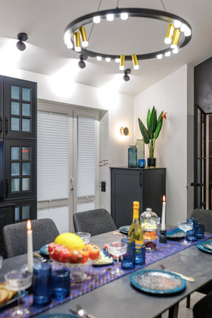 A modern living room with a blue sofa and a fixed table. Ceiling with wooden beams. open space.の写真素材