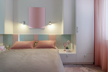 A modern bedroom in blue, pink and white colors with muffled lighting. real photo.の写真素材