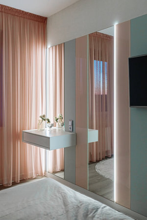 Stylish bedroom interior with an elegant white toilet table, with muffled lighting.の写真素材