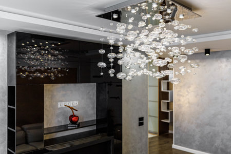 Black bio fireplace in the living room with large crystal chandelier in the apartment.の写真素材