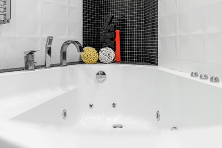 Bathroom with shower and large bathtub bathtub with contrasting white and black walls.の写真素材