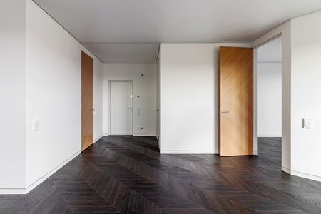 Empty room with dark wooden floating laminate flooring. House interior, wide bedroom or living room space. Newly recently painted new apartment or house. wood floor. Real estate or property management.の写真素材
