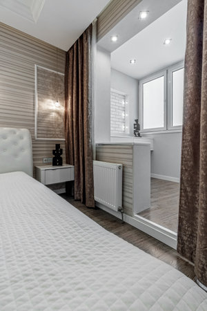 Bright bedroom with large white bed and capitone headboard.の写真素材