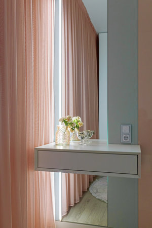 Stylish bedroom interior with an elegant white toilet table, with muffled lighting.の写真素材