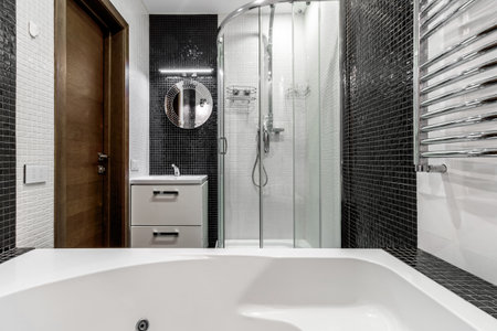 Bathroom with shower and large bathtub bathtub with contrasting white and black walls.の写真素材